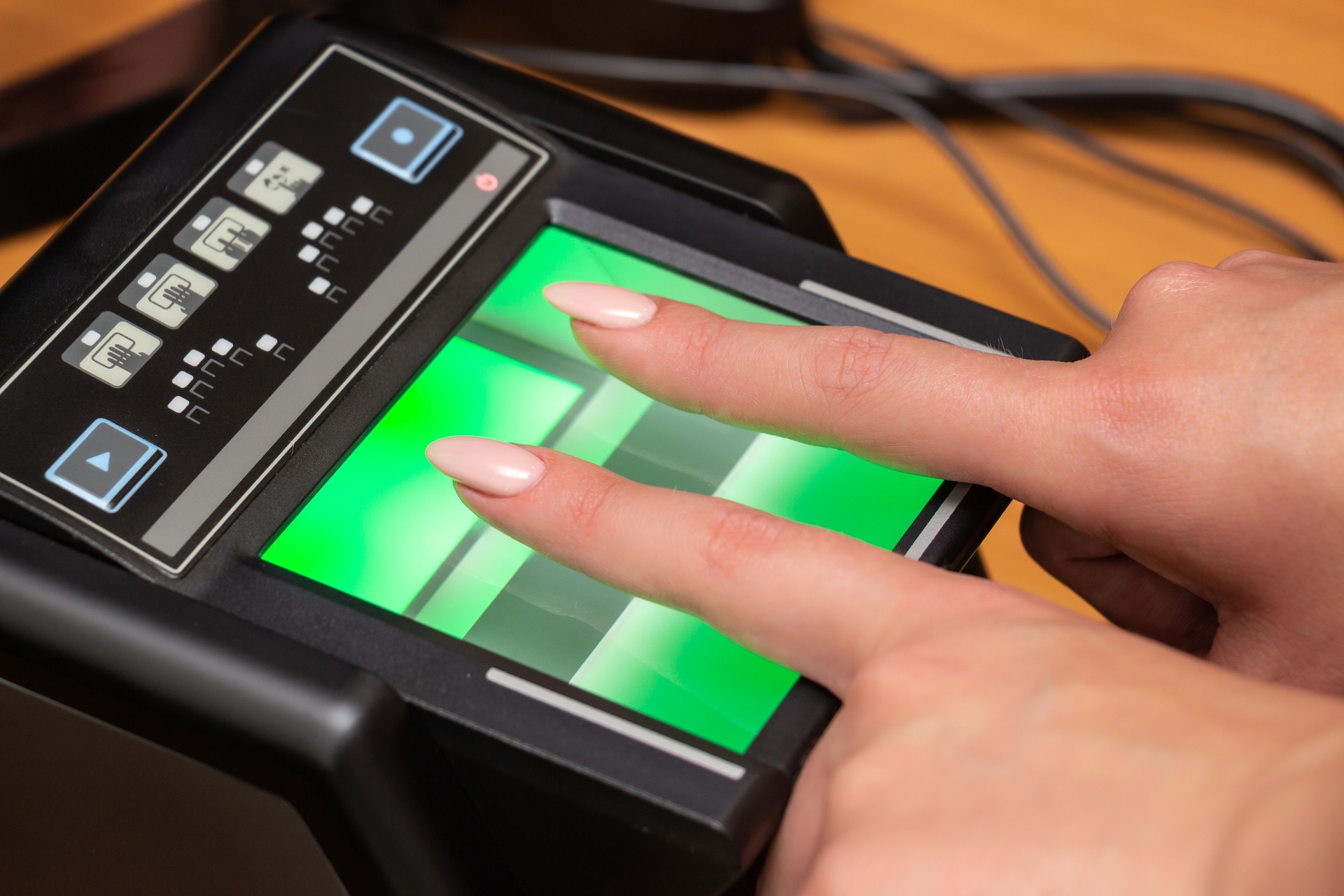 The process of scanning fingerprints during the check at border crossing. Female hand puts fingers to the fingerprint scanner. Biometric, identity verification and border control, immigration concept